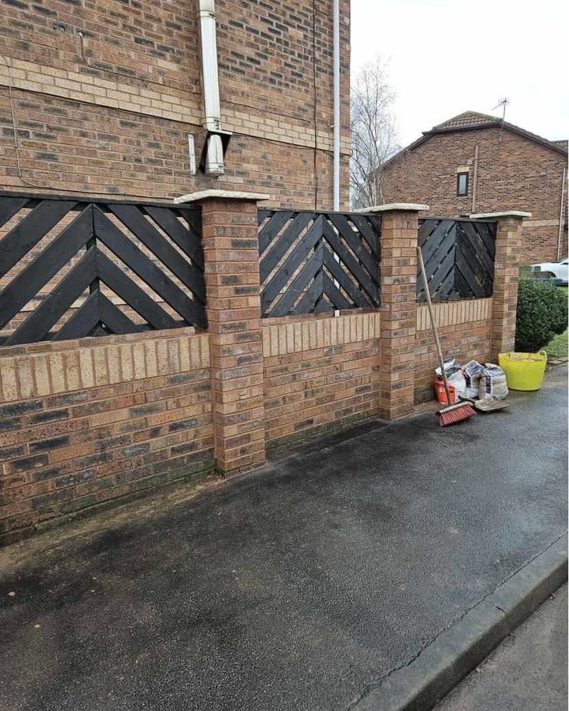 Brick garden wall with piers and black chevron fence panels